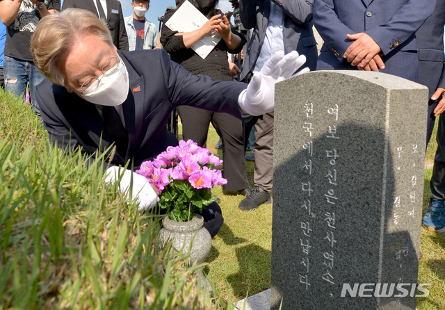 [광주=뉴시스] 변재훈 기자 = 더불어민주당 대권 주자인 이재명 경기도지사가 5·18민주화운동 41주기를 맞아 18일 오후 광주 북구 운정동 국립 5·18민주묘지에서 참배하며 항쟁 당시 임신부 희생자 최미애 열사 묘비를 어루만지고 있다. 2021.05.18. wisdom21@newsis.com