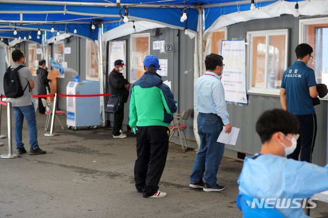 [서울=뉴시스]배훈식 기자 = 코로나19 신규 확진자수가 다시 600명대로 올라선 19일 오전 서울 중구 서울역 광장에 마련된 코로나19 임시선별진료소를 찾은 시민들이 줄을 서고 있다. 2021.05.18. dahora83@newsis.com