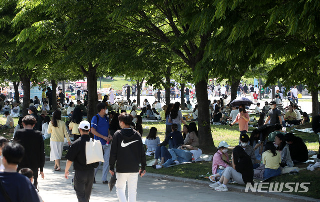 [서울=뉴시스]박주성 기자 = 부처님오신날인 19일 서울의 한 낮 기온이 27도로 초여름 날씨를 보인 가운데 여의도 한강공원에 시민들이 나무 그늘 아래서 휴일을 즐기고 있다. 2021.05.19. park7691@newsis.com