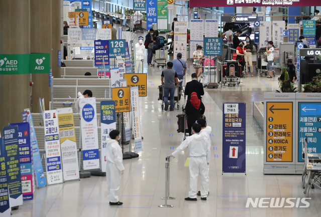 [인천공항=뉴시스]고승민 기자 = 지난달 20일 인천국제공항 1터미널 입국장에서 방역 관계자들이 업무를 보고 있다. 2021.05.20. kkssmm99@newsis.com