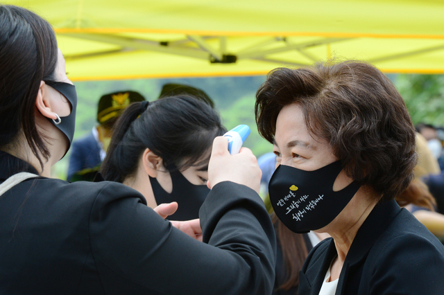 [김해=뉴시스]차용현 기자 = 23일 오전 경남 봉하마을 대통령 묘역에서 엄수된 故 노무현 전 대통령 서거 12주기 추도식에서 추미애 전 장관이 발열체크를 하고 있다.(공동취재사진) 2021.05.23. con@newsis.com