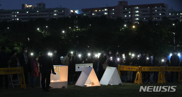 [서울=뉴시스]조수정 기자 = 지난 5월23일 오후 서울 반포한강공원 택시승강장 인근에 마련된 고(故) 손모씨 추모공간 인근에서 열린 진상규명 촉구 집회. 손씨는 지난 4월24일 반포한강공원에서 술을 마신 뒤 실종됐다가 30일 인근 한강 수중에서 숨진 채 발견됐다. 2021.05.23. chocrystal@newsis.com
