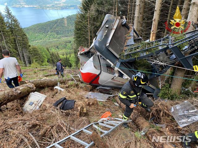 [피아몬테=AP/뉴시스]23일(현지시간) 이탈리아 북부 피아몬테 지역에서 케이블카 추락 사고가 발생해 구조대원들이 잔해를 뒤지고 있다. 2021.05.24. 