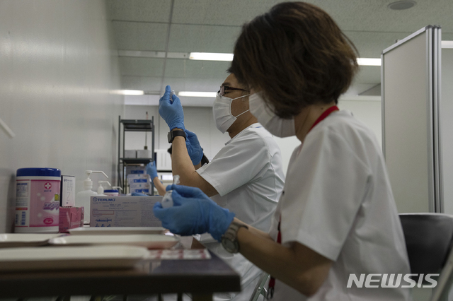 [도쿄=AP/뉴시스]24일 일본 도쿄에 새로 개소한 코로나19 대량접종센터에서 한 노인이 모더나 백신을 접종하고 있다. 일본은 하루 최대 1만5000명의 노인을 대상으로 도쿄와 오사카 두 곳에 대량접종 센터를 개설했다. 2021.05.24.