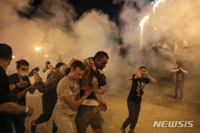 [민스크=AP/뉴시스]지난해 8월10일 벨라루스 민스크에서 열린 반정부 시위에서 시민들이 경찰 진압으로 부상을 입은 참가자를 부축해 옮기고 있다. 2021.05.25.