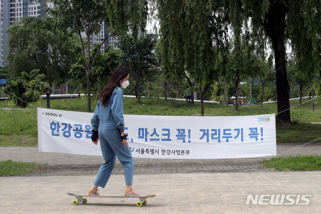 [서울=뉴시스]김병문 기자 = 정부가 예방접종 완료자 일상회복 지원 방안을 발표한 26일 오전 서울 서초구 반포 한강공원에 마스크 착용 의무 현수막이 걸려 있다. 2021.05.26. dadazon@newsis.com