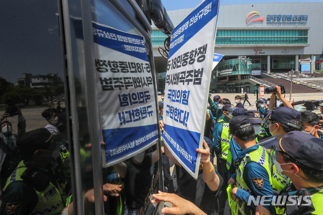 [광주=뉴시스] 변재훈 기자 = 광주전남대학생진보연합회 소속 대학생들이 30일 광주 서구 치평동 김대중컨벤션센터에서 국민의힘 당직자·수행원 등이 탄 버스 앞을 막아서고 있다. 2021.05.30. wisdom21@newsis.com