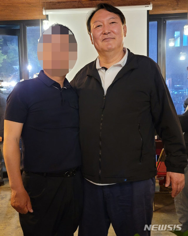 [강릉=뉴시스] 김경목 기자 = 야권의 유력 대선주자인 윤석열 전 검찰총장이 지난 29일 오후 강원도 강릉시 교동의 한 커피숍에서 시민과 포즈를 취하고 있다. (사진=독자 제공) 2021.05.31. photo@newsis.com *재판매 및 DB 금지