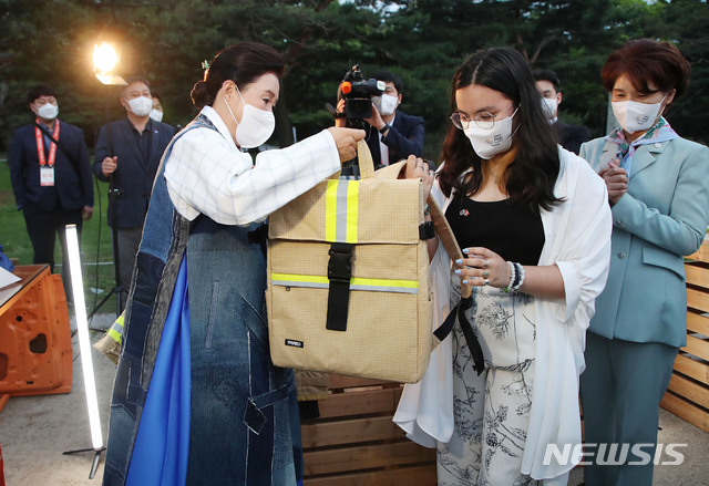 [서울=뉴시스]김진아 기자 = 문재인 대통령 부인 김정숙 여사가 31일 오후 서울 경복궁 경회루에서 열린 ‘2021 P4G서울 녹색미래 정상회의 새활용 의류전’에서 후안 호세 플라센시아 바스케스 주한 페루 대리대사 자녀에게 소방복 새활용 가방을 선물하고 있다. 2021.05.31. bluesoda@newsis.com