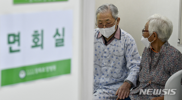 [서울=뉴시스]사진공동취재단 = 요양병원·시설 입소자나 면회객 중 어느 한쪽이라도 코로나 19 예방접종 완료자(2차 접종 후 2주 경과)인 경우 대면 면회가 가능해진 1일 오전 경기도 안산시 단원구 경희재활요양병원에서 아내 이 모씨와 입소자인 남편 김 모씨가 대면 면회를 하고 있다. 2021.06.01. photo@newsis.com