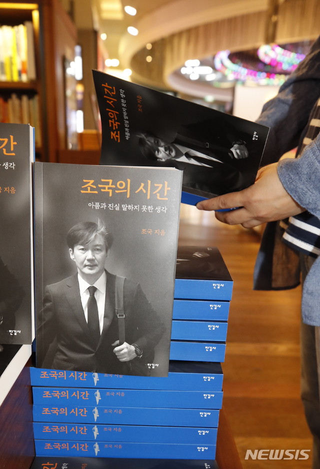 [서울=뉴시스]김형수 기자 = 3일 오전 서울 종로구 교보문고 광화문점을 찾은 한 시민이 조국 전 법무부 장관의 회고록 ‘조국의 시간’을 읽어보고 있다. 2021.06.03. kyungwoon59@newsis.com