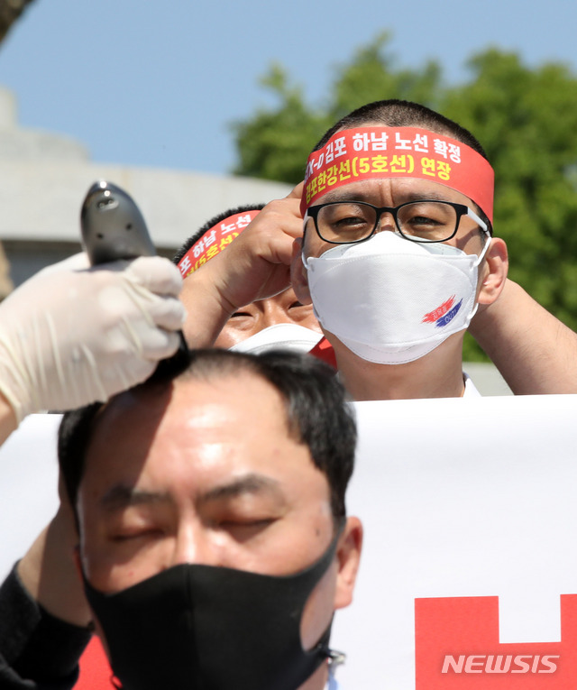 [서울=뉴시스]고범준 기자 = 김포검단교통시민연대 회원들이 4일 오후 서울 청와대 분수대 앞에서 'GTX-D 원안 사수와 지하철 5호선 연장'을 촉구하는 삭발을 하고 있다. 2021.06.04. bjko@newsis.com