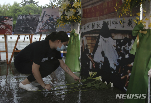 [타이베이=AP/뉴시스] 대만 수도 타이베이 민주광장에서 2021년 6월 4일 코로나19 예방을 위해 마스크를 착용한 여성이 중국군이 민주화 시위대를 유혈진압한 톈안먼 사태 32주년을 맞아 희생자를 추모하는 제단에 헌화하고 있다. 2024.08.22.
