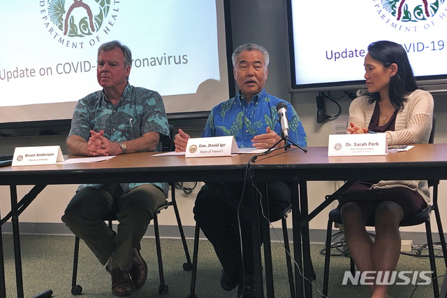 [호놀룰루( 하와이)=AP/뉴시스] 지난 해 2월 하와이주의 코로나 감염이 급증할 당시 브리핑에서 코로나19 방역대책을 발표하는 데이비드 이게 하와이주지사(가운데). 관광산업이 경제의 주축인 하와이는 주민 대상의 백신접종 운동을 펴면서 경제 재개를 준비하고 있다.  
