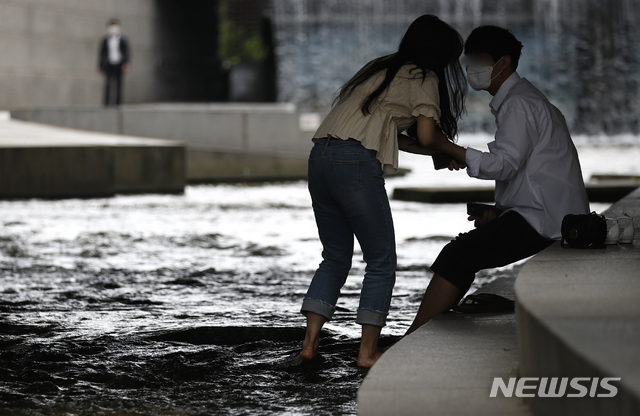 [서울=뉴시스]정병혁 기자 = 서울 낮 최고기온이 30도까지 오르는 등 더운 날씨가 이어지고 있는 지난해 6월10일 서울 중구 청계천에서 시민들이 물에 발을 담그고 있다. 2021.06.10. jhope@newsis.com