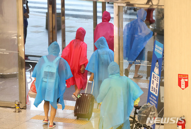 [제주=뉴시스]우장호 기자 = 한라산 등 고지대에 많은 비가 내리는 11일 오전 제주국제공항 1층 도착장에 우비를 입은 관광객들이 이동하고 있다. 2021.06.11. woo1223@newsis.com