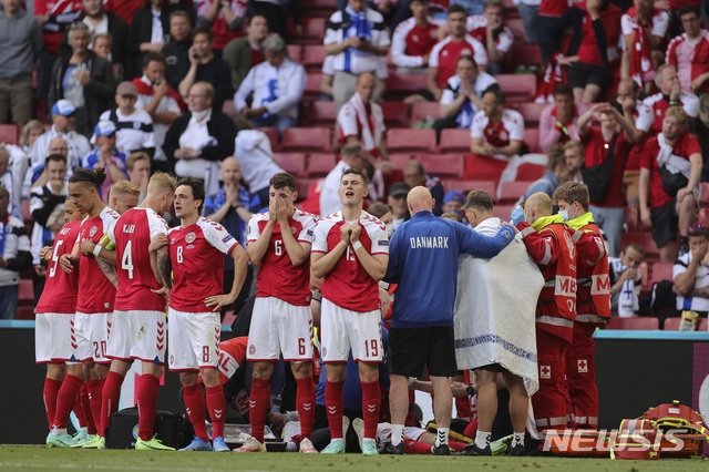 Denmark players react after the collapsing of their teammate Christian Eriksen during the Euro 2020 soccer championship group B match between Denmark and Finland at Parken stadium in Copenhagen, Denmark, Saturday, June 12, 2021. (Friedemann Vogel/Pool via AP)