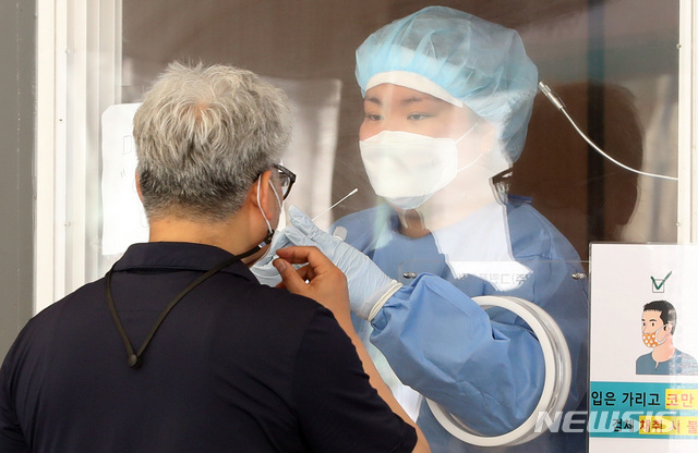 [서울=뉴시스]전진환 기자 = 지난 13일 오전 서울 중구 서울역 앞에 마련된 코로나19 선별진료소에서 한 시민이 검체 채취를 받고 있다. 2021.06.13. amin2@newsis.com