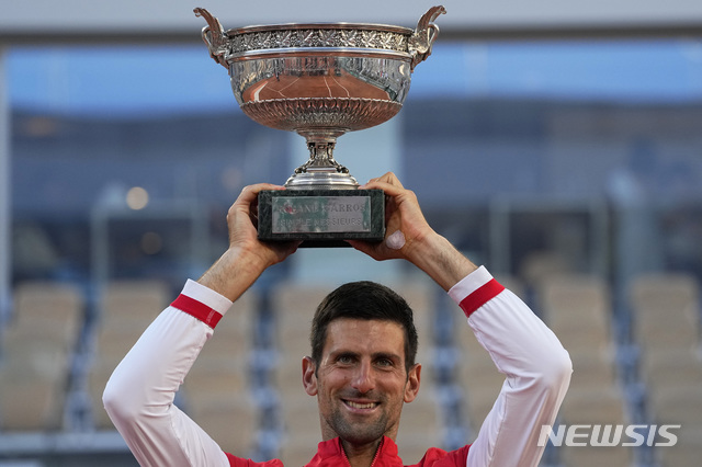 [파리=AP/뉴시스]노바크 조코비치(1위·세르비아)가 13일(현지시간) 프랑스 파리의 스타드 롤랑가로스에서 열린 프랑스오픈 테니스 대회 남자 단식 정상에 올라 트로피를 들고 포즈를 취하고 있다. 조코비치는 결승전에서 스테파노스 치치파스(5위·그리스)를 4시간 11분의 혈투 끝에 세트스코어 3-2(6-7<6-8> 2-6 6-3 6-2 6-4)로 역전승을 거두고 5년 만에 우승컵을 안았다. 2021.06.14.