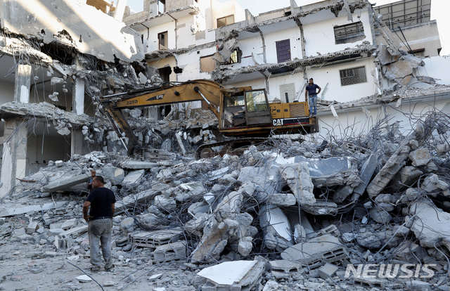 [가자시티=AP/뉴시스] 15일(현지시간) 가자지구 내 가자시티에서 이스라엘 공습으로 파괴된 건물 잔해 제거 작업이 진행되고 있다. 이 건물은 지난달 이스라엘과 하마스 간 11일간의 무력 충돌 중 파손됐다. 2021.06.16.