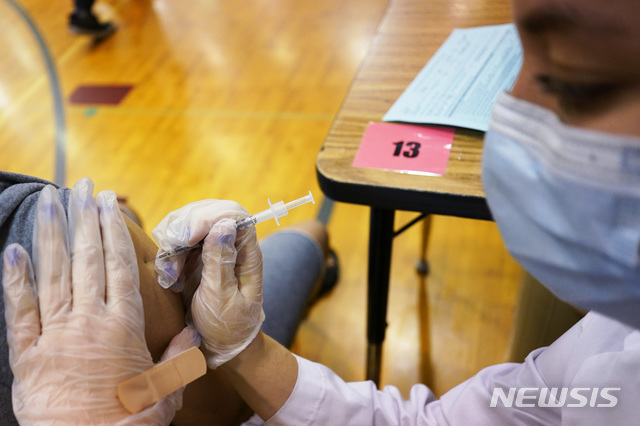 [런던=AP/뉴시스] 지난달 11일 영국 런던 한 중학교에서 의료진이 학생들에게 화이자 백신을 접종하고 있다. 2021.07.20.