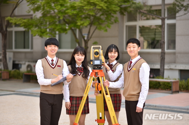 [서울=뉴시스]서울 성북구 소재 마이스터고(산업수요 맞춤형 고등학교)인 도시과학기술고등학교 해외시설물건설과 학생들이 측량 기기 앞에서 포즈를 취하고 있다. 코로나19 이전에 촬영된 사진. (사진=도시과학기술고 제공). 2021.06.18. photo@newsis.com