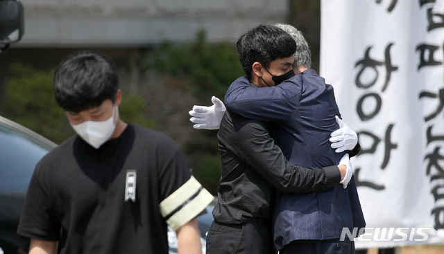 [평택=뉴시스]김선웅 기자 = 19일 오전 경기 평택시 안중백병원 장례식장에서 열린 청년 노동자 故 이선호 씨 시민사회장에서 고인의 부친 이재훈 씨가 발언을 마친 고인의 친구들과 슬픔을 나누고 있다. 고인은 지난 4월 경기 평택항에서 개방형 컨테이너 벽체에 깔려 산재 사망사고를 당했다. 2021.06.19. mangusta@newsis.com