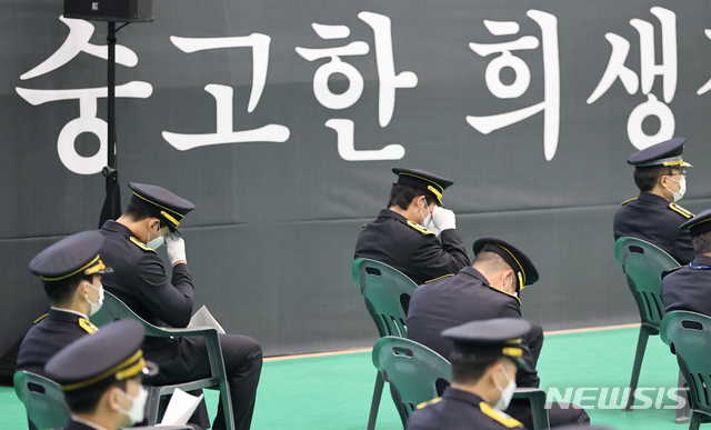 [광주(경기)=뉴시스]사진공동취재단 = 이천 쿠팡 물류센터 화재현장에서 진화 작업 중 순직한 고(故) 김동식 구조대장의 영결식이 21일 오전 경기 광주시민체육관에서 경기도청장(葬)으로 엄수된 가운데 동료  소방관들이 눈물을 흘리고 있다. 경기도는 고인에게 소방경에서 소방령으로 1계급 특진과 녹조근정훈장을 추서했다. 2021.06.21. photo@newsis.com