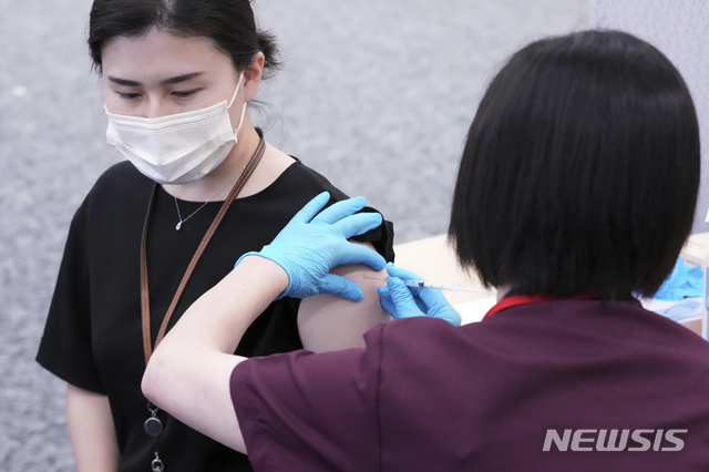[도쿄=AP/뉴시스]21일 일본 도쿄에 있는 음료 제조업체 산토리에서 이곳 직원이 모더나 백신을 접종하고 있다. 일본 정부가 21일부터 도쿄도 등에 내렸던 코로나19 긴급사태 선언을 해제했으며 직장과 대학교에서의 백신 접종도 본격적으로 시작했다. 이에 따라 일본 기업들은 고용주 주도하에 근로자와 그 가족들에게 코로나19 백신을 접종하기 시작해 1300만 명 이상 접종을 목표로 하고 있다. 2021.06.21.