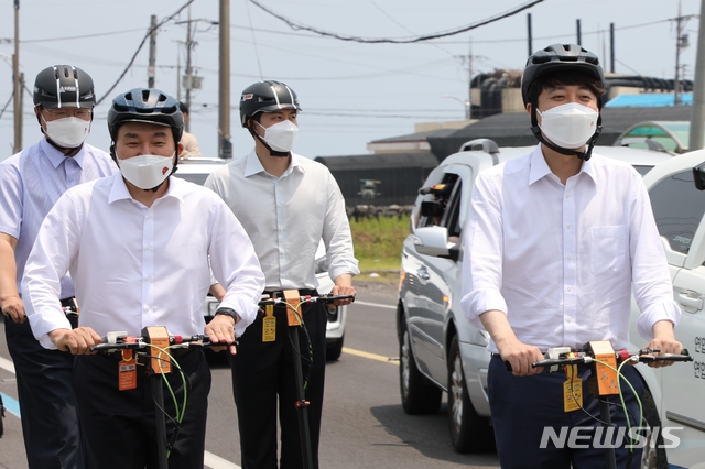 [제주=뉴시스] 강경태 기자 = 이준석 국민의힘 대표(오른쪽)와 원희룡 제주특별자치도지사가 23일 오전 제주시 구좌읍 행원리 해안도로에서 전동 킥보드를 타고 이동하고 있다. 2021.06.23. ktk2807@newsis.com