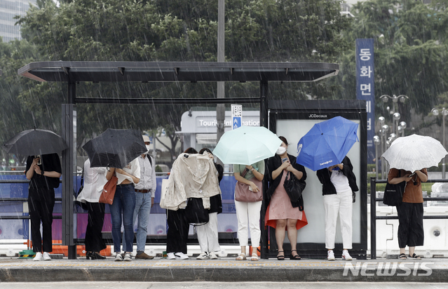 [서울=뉴시스]정병혁 기자 = 지난 23일 서울 종로구 광화문네거리 인근 버스정류장에서 갑자기 내린 소나기에 시민들이 비를 피하고 있다. 2021.06.23. jhope@newsis.com