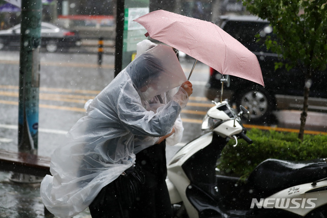 [서울=뉴시스]이영환 기자 = 소나기가 내린 지난 23일 오후 서울 종로구 청운효자동주민센터 인근에서 시민들이 우산을 쓰고 걸어가고 있다. 2021.06.23. 20hwan@newsis.com