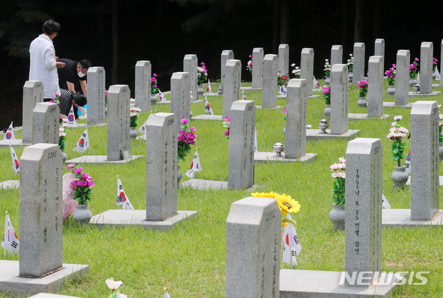 [서울=뉴시스]배훈식 기자 = 6.25 전쟁 71주년을 하루 앞둔 24일 오후 서울 동작구 국립서울현충원에서 한 유족이 가족의 묘를 찾아 참배하고 있다. 2021.06.24. dahora83@newsis.com