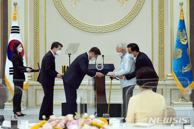 [서울=뉴시스]김진아 기자 = 문재인 대통령이 24일 청와대 영빈관에서 열린 '국가유공자 및 보훈가족 초청 오찬'에 참석해 6.25전쟁 참전용사인 하사용 씨에게 국민훈장 동백장을 수여하고 있다. 2021.06.24. bluesoda@newsis.com