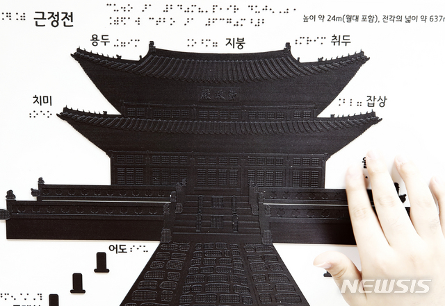 [서울=뉴시스]정병혁 기자 = 25일 오전 서울 종로구 경복궁을 찾은 한 시각장애인이 경복궁 촉각그림카드로 관람교육을 받고 있다. 이날 문화재청 경복궁관리소는 경복궁 촉각그림카드와 모형을 활용해 경복궁을 관람하는 시각장애인 맞춤형 문화탐방 체험프로그램을 진행했다. 2021.06.25. jhope@newsis.com