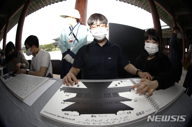 [서울=뉴시스]정병혁 기자 = 25일 오전 서울 종로구 경복궁을 찾은 한 시각장애인이 경복궁 촉각그림카드로 관람교육을 받고 있다. 이날 문화재청 경복궁관리소는 경복궁 촉각그림카드와 모형을 활용해 경복궁을 관람하는 시각장애인 맞춤형 문화탐방 체험프로그램을 진행했다. 2021.06.25. jhope@newsis.com