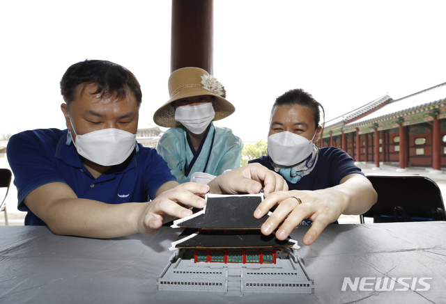 [서울=뉴시스]정병혁 기자 = 25일 오전 서울 종로구 경복궁을 찾은 시각장애인들이 근정전 모형을 만지며 관람교육을 받고 있다. 이날 문화재청 경복궁관리소는 경복궁 촉각그림카드와 모형을 활용해 경복궁을 관람하는 시각장애인 맞춤형 문화탐방 체험프로그램을 진행했다. 2021.06.25. jhope@newsis.com