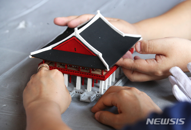 [서울=뉴시스]정병혁 기자 = 25일 오전 서울 종로구 경복궁을 찾은 시각장애인들이 경회루 모형을 만져보며 관람교육을 받고 있다. 이날 문화재청 경복궁관리소는 경복궁 촉각그림카드와 모형을 활용해 경복궁을 관람하는 시각장애인 맞춤형 문화탐방 체험프로그램을 진행했다. 2021.06.25. jhope@newsis.com