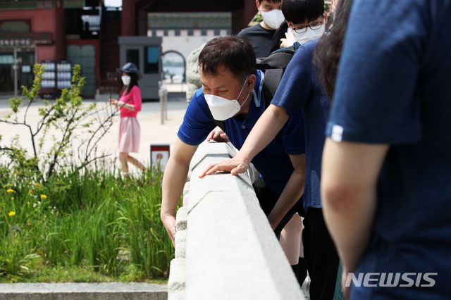 [서울=뉴시스]정병혁 기자 = 25일 오전 서울 종로구 경복궁을 찾은 한 시각장애인이 영제교를 만져보고 있다. 이날 문화재청 경복궁관리소는 경복궁 촉각그림카드와 모형을 활용해 경복궁을 관람하는 시각장애인 맞춤형 문화탐방 체험프로그램을 진행했다. 2021.06.25. jhope@newsis.com