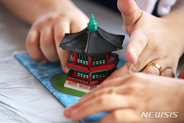 [서울=뉴시스]정병혁 기자 = 25일 오전 서울 종로구 경복궁을 찾은 시각장애인들이 향원정 모형을 만져보며 관람교육을 받고 있다. 이날 문화재청 경복궁관리소는 경복궁 촉각그림카드와 모형을 활용해 경복궁을 관람하는 시각장애인 맞춤형 문화탐방 체험프로그램을 진행했다. 2021.06.25. jhope@newsis.com