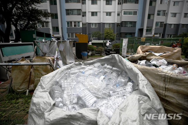 [서울=뉴시스]정병혁 기자 = 투명 페트병 별도 분리배출제를 위반하면 30만원 이하의 과태료가 부과된다. 폐기물관리법 시행령에 따라 계도기간이 끝나는 지난달 26일부터 위반 시 1차 10만원, 2차 20만원, 3차 위반부터 30만원의 과태료가 아파트 관리사무소에 부과된다. 투명 페트병 별도 분리배출제는 투명 플라스틱병의 라벨을 떼고 다른 플라스틱과 섞이지 않게 분리배출하는 제도로, 지난해 12월부터 공동주택을 대상으로 의무화됐다. 사진은 26일 서울시내의 한 아파트 분리수거장의 모습. 2021.06.26. jhope@newsis.com