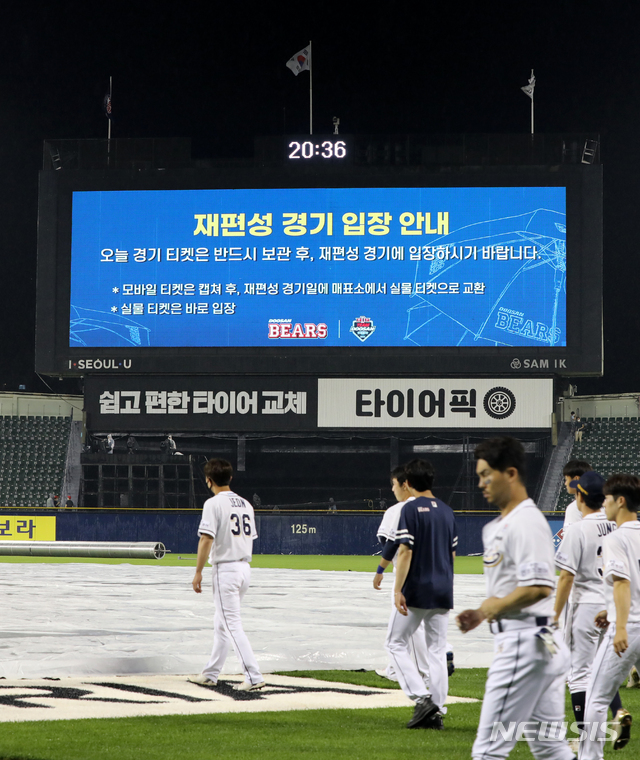 [서울=뉴시스]고범준 기자 = 27일 오후 서울 송파구 잠실야구장에서 열린 2021 KBO리그 두산 베어스와 롯데 자이언츠의 경기, 7회초 3-2로 롯데가 앞선 상황에서 우천으로 중단된 후 서스펜디드 게임으로 선언됐다. 선수들이 경기장을 나가고 있다. 2021.06.27. bjko@newsis.com