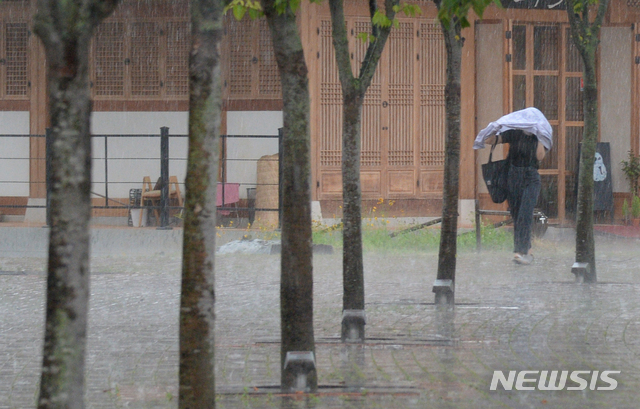 [전주=뉴시스]김얼 기자 = 전북 전주시에 소나기와 더불어 우박이 내리기 시작한 28일 전북대학교에서 학생이 비를 피하며 교정을 지나고 있다. 2021.06.28. pmkeul@newsis.com