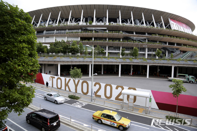 [도쿄=AP/뉴시스]지난달 29일 도쿄올림픽 경기가 열릴 일본 도쿄 국립경기장의 앞으로 차들이 지나가고 있다. 도쿄올림픽은 오는 23일 개막한다. 2021.07.07.