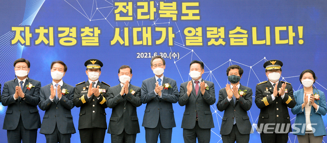 [전주=뉴시스]김얼 기자 = 송하진(가운데) 전북도지사를 비롯한 관계자들이 30일 전북 전주시 전북도청 공연장에서 열린 전라북도 자치경찰 출범식에 참석해 기념촬영을 하고 있다. 2021.06.30. pmkeul@newsis.com