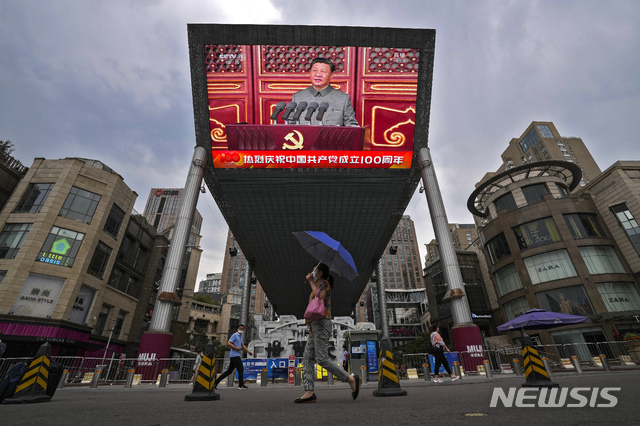 [베이징=AP/뉴시스]1일 중국 베이징의 톈안먼 광장에서 중국공산당 창당 100주년 기념행사가 열려 시진핑 중국 국가주석이 연설하는 대형 비디오 스크린 앞으로 시민들이 지나가고 있다. 2021.07.01.
