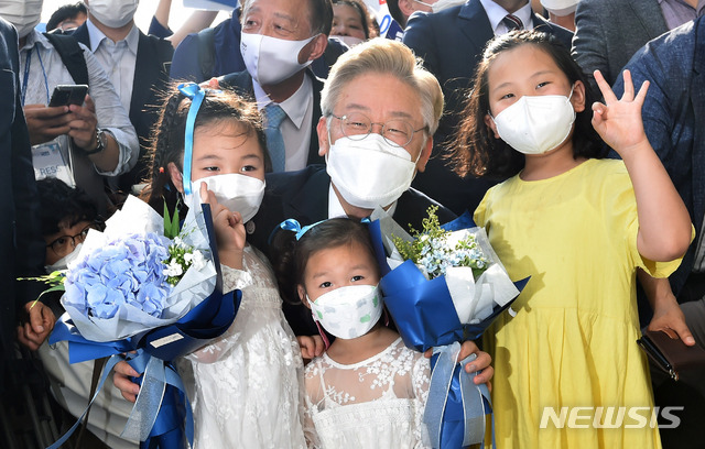 [안동=뉴시스]이무열 기자 = 대선 출마를 선언한 이재명 경기도지사가 1일 오후 경북 안동시 경상북도 유교문화회관을 방문한 자리에서 어린이로부터 환영 꽃다발을 받은 후 기념사진을 찍고 있다. 2021.7.01. lmy@newsis.com