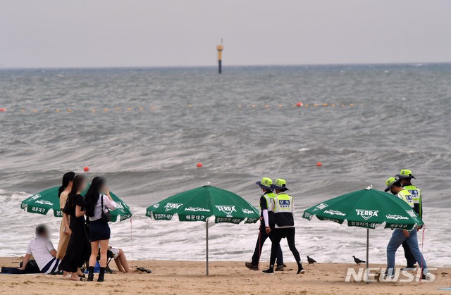 [부산=뉴시스]하경민 기자 = 부산지역 7개 해수욕장이 전면 개장한 이후 첫 주말인 4일 오후 부산 해운대구 해운대해수욕장에서 단속요원들이 피서객들을 대상으로 마스크 착용, 4인 이상 사적모임 금지 등 방역수칙 준수여부를 계도·단속하고 있다. 2021.07.04. yulnetphoto@newsis.com