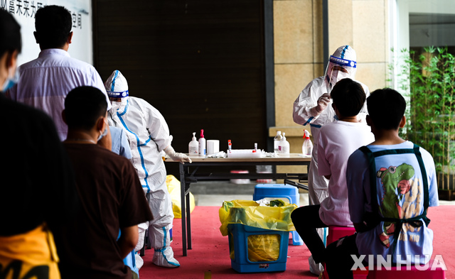 [루이리(윈난성)=신화/뉴시스] 지난 5일 중국 윈난성 루이리시에서 방역 요원이 주민들을 상대로 코로나19 검사를 실시하고 있다. 2021.07.07 