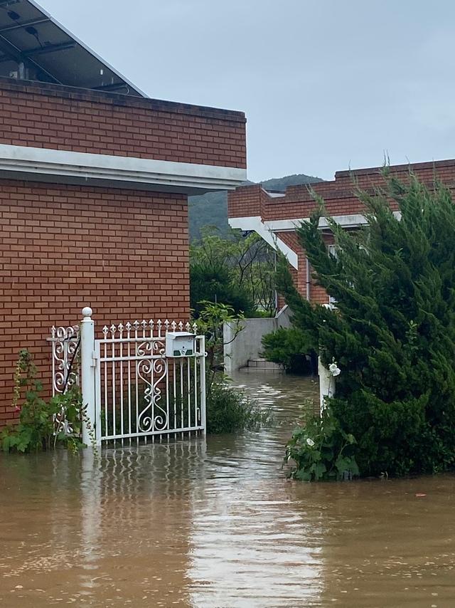 [창원=뉴시스] 강경국 기자 = 경남 창원시 의창구 북면 신촌리의 한 주택이 6일 오전 집중호우로 불어난 하천이 범람하면서 침수 위험에 놓여 있어 있다. (사진=창원소방본부 제공). 2021.07.06. photo@newsis.com *재판매 및 DB 금지
